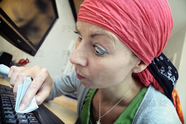 Cleaning lady cleaning a computer keyboard