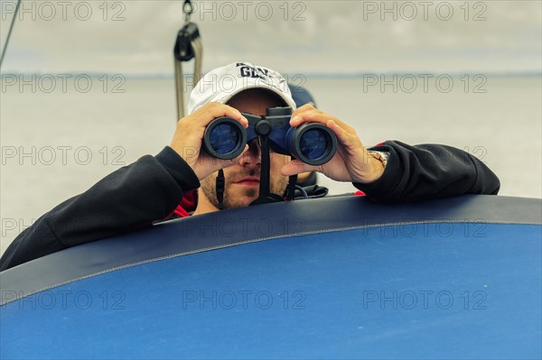 Man looking through binoculars