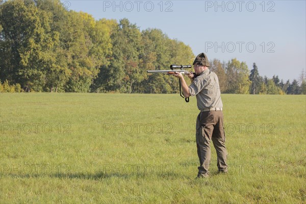 Hunter waiting for game with weapon at the ready