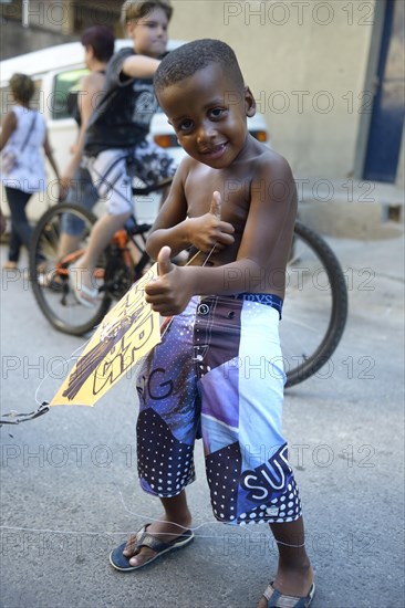 Young boy holding a kite in a slum or favela