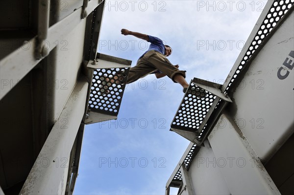 Illegal immigrant from Latin America on his way to the U.S. jumping from one waggon to another trying to reach the U.S. border as a stowaway on freight trains