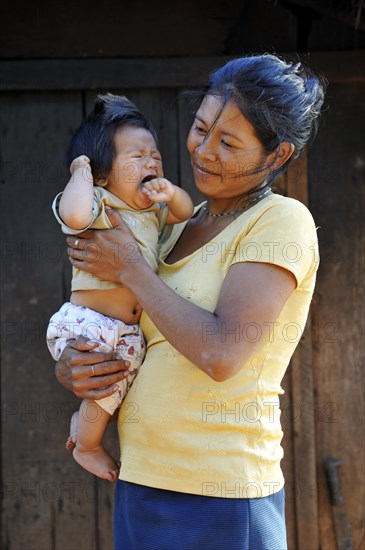 Young mother holding a crying child in her arms
