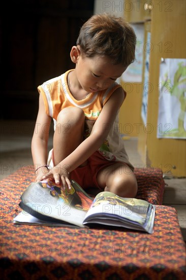 Young leafing through a book in a local library