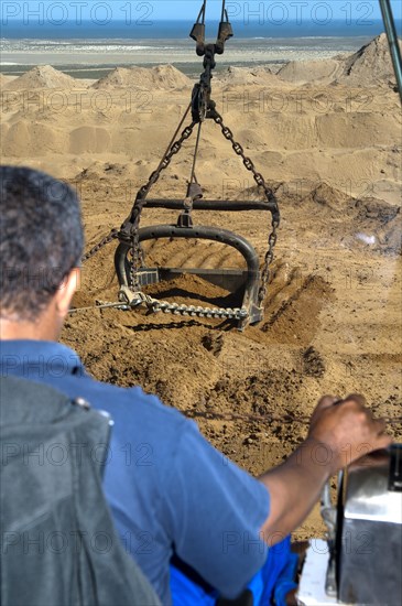 Excavator operator in the cab of a dragline excavator working in the diamond mine of De Beers Namaqualand Mines