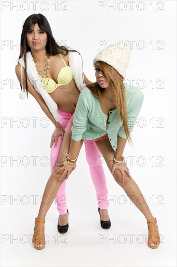 Two young Asian women posing in colourful outfits