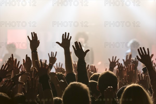 Concertgoers stretching their hands in the air at the concert of the Swiss pop band Pegasus