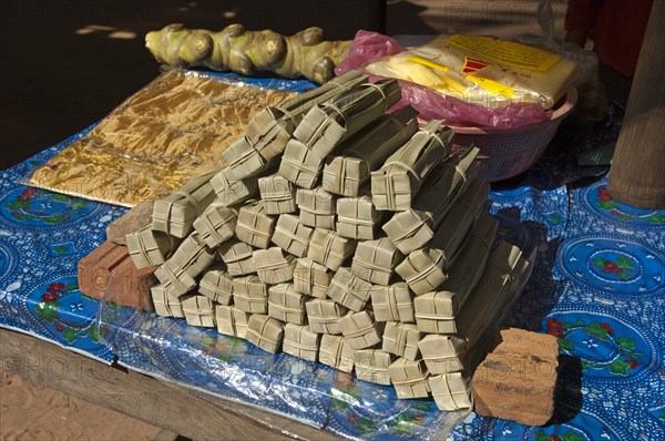 Palm sugar packed in palm leaves for sale at a market stall
