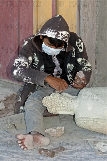 Stonemason working on a Buddha statue