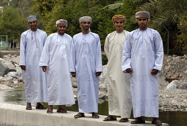 Five young Omani men wearings traditional dishdasha festive clothes during a trip to the hot springs of Ain A'Thawwarah