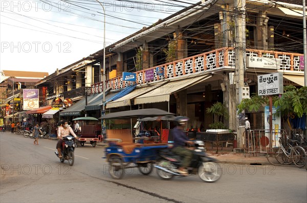 Rickshaw in traffic in front of restaurants and bars in Pub Street