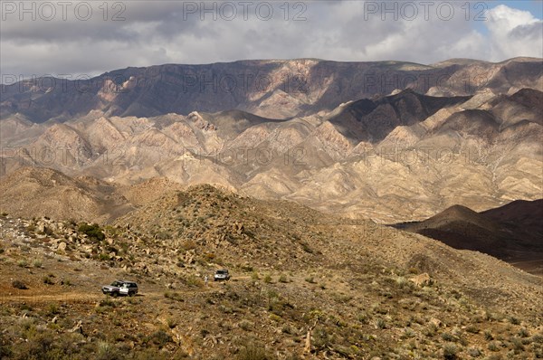 Broad hilly landscape with two all-terrain vehicles