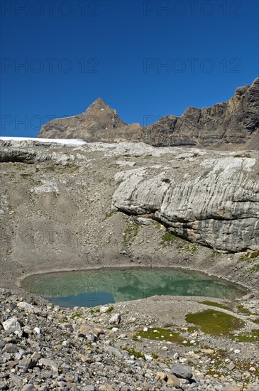 Lake of green meltwater in a doline or sinkhole in the end moraine of Tsanfleuron Glacier at Sanetsch Pass