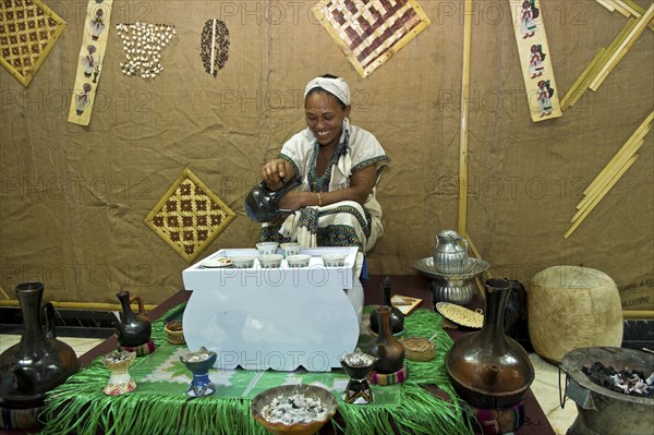 Ethiopian woman pours coffee in a traditional coffee ceremony