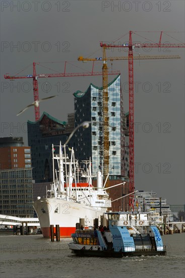 Ferry crossing the canal in front of the Cap San Diego and the Elbe Philharmonic Hall