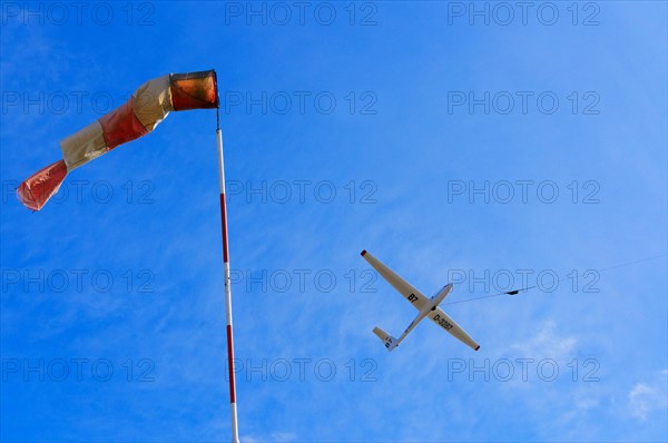 Windsock and a glider during a winch launch against the wind