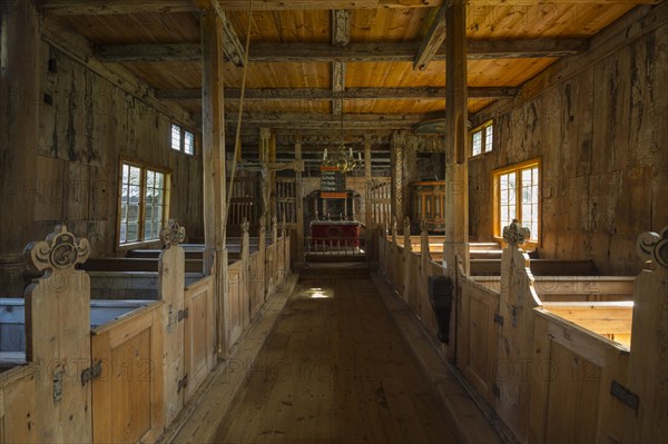 Stave church interior with pews and an altar