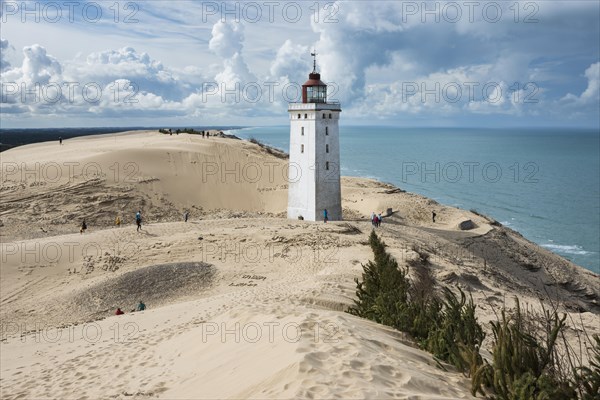 Lighthouse with the Rubjerg Knude migrating dune on the North Sea coast