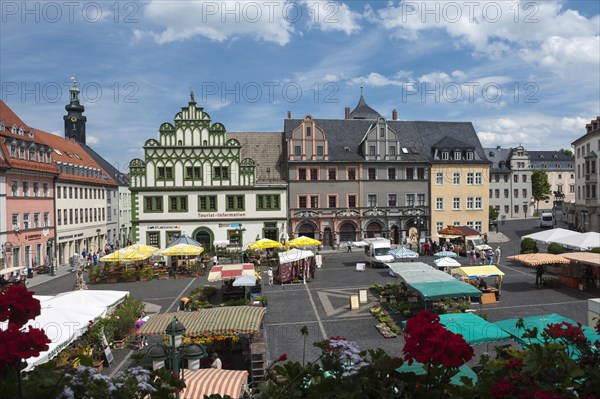 Weekly market on the market square in front of Lucas Cranach house and a town house with half-timbered gables