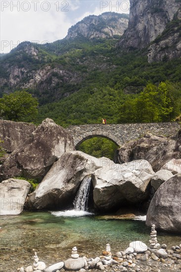 Medieval bridge with hikers near Fontana