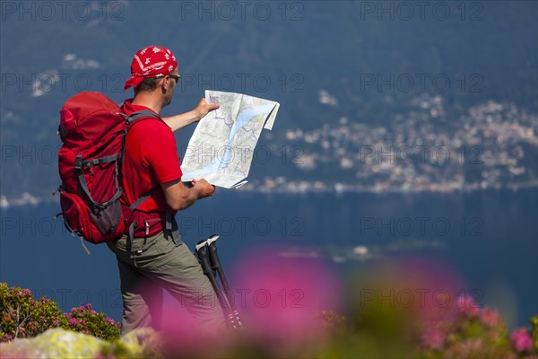 Man studying the trail map while hiking on Monte Covreto