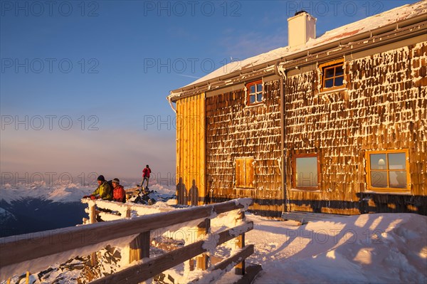 Two mountaineers watching the sunrise at the Archduke Johann cabin on Mt Grossglockner