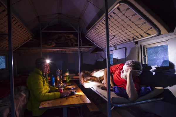 A man and a woman inside the Bivacco del Baus refuge