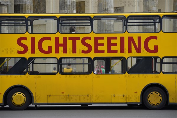 Yellow sightseeing bus in front of the Brandenburg Gate