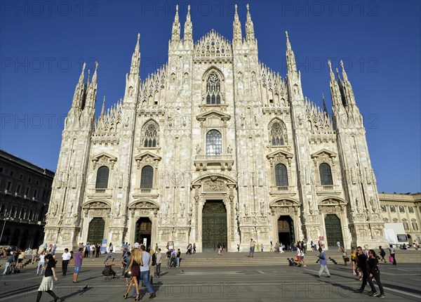 Tourists in front of the west facade of Milan Cathedral or Duomo di Santa Maria Nascente