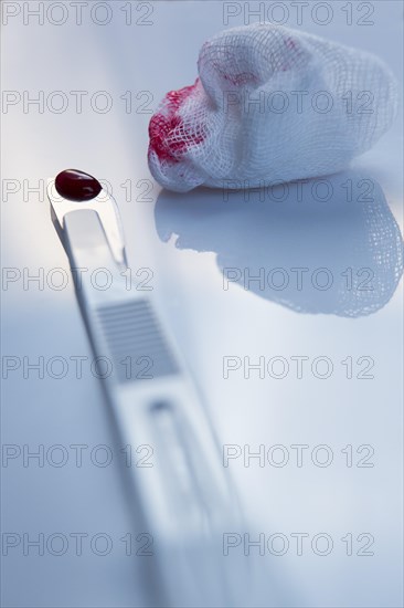 Scalpel and blood on a cotton swab