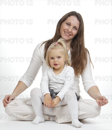 Girl sitting on lap of a woman sitting cross-legged