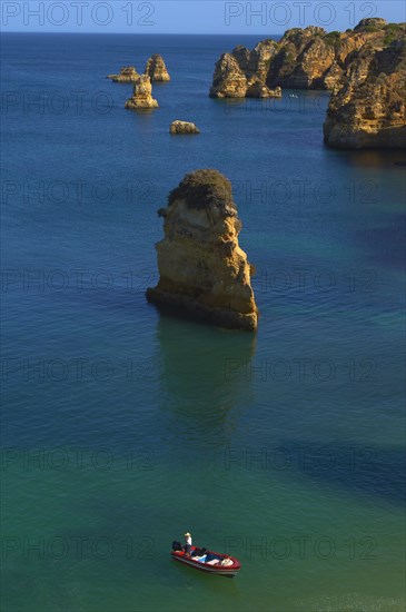 Boat off the cliffs at Praia da Dona Ana beach