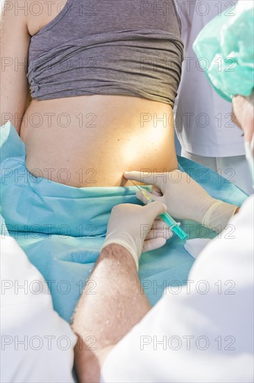 Pregnant women during delivery in the delivery room with an anesthesiologist applying a PDA or epidural