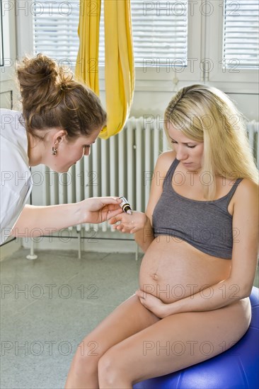 Pregnant woman recieving homeopathic medicine from her midwife during delivery