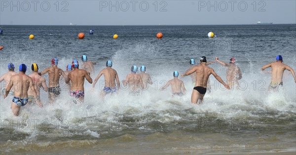 Men running into the sea