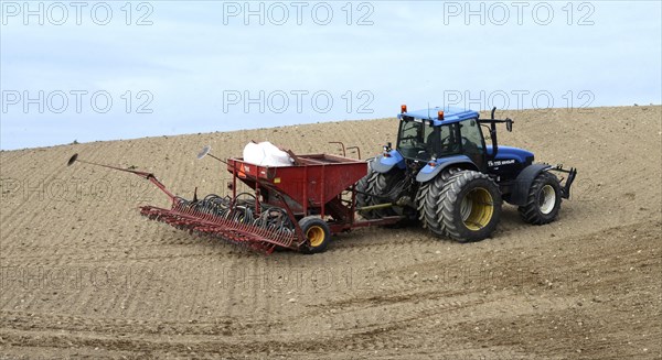 Tractor planting wheat seeds in autumn