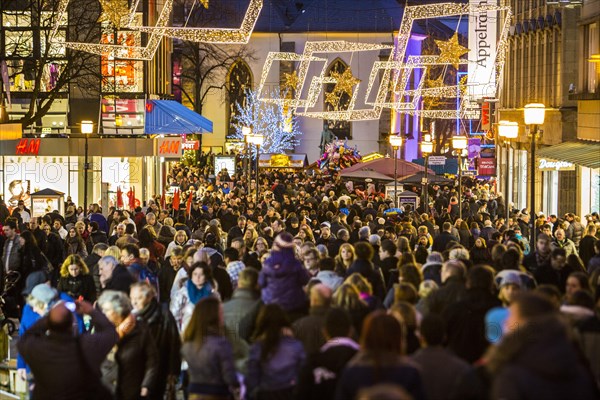 Crowds thronging between stores and Christmas market stalls