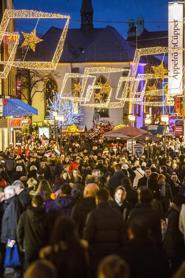 Crowds thronging between stores and Christmas market stalls