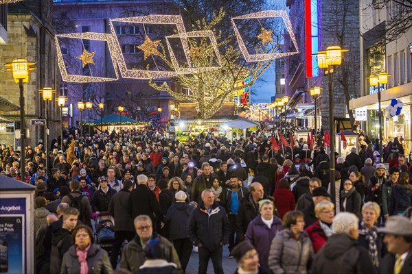 Crowds thronging between stores and Christmas market stalls