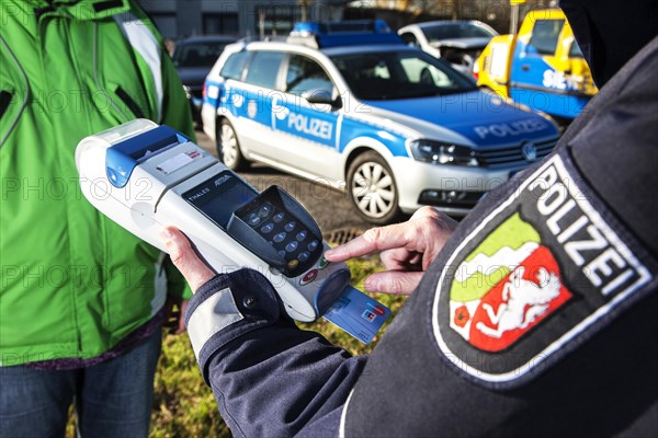 Police officer collecting an on-the-spot fine with a card reader