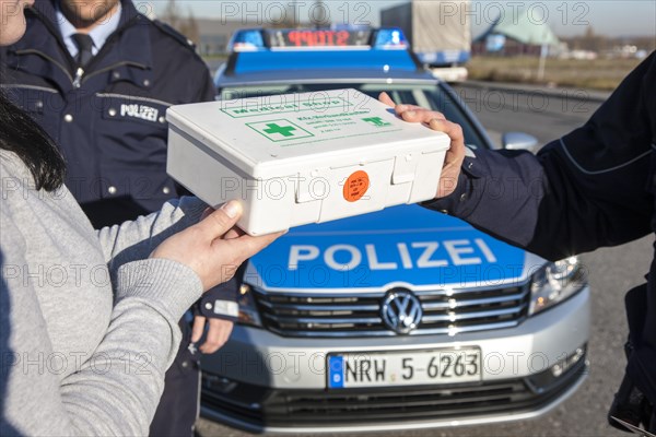 Policeman checking a first aid box during a traffic control