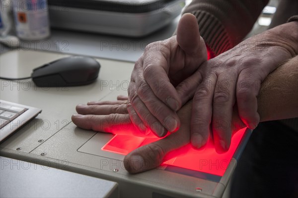 Fingerprints and palm prints of a suspicious person are recorded with a scanner