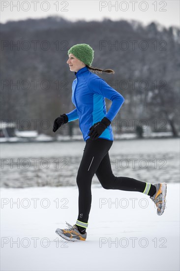 Female jogger on a run in winter at Lake Baldeney