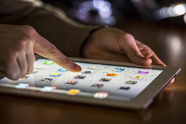 Finger touching the touch screen of an Apple iPad