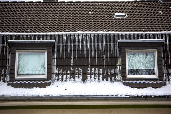 Large icicles hanging from the eaves of a house