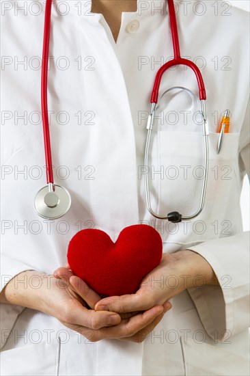 Female doctor holding a red heart in her hands