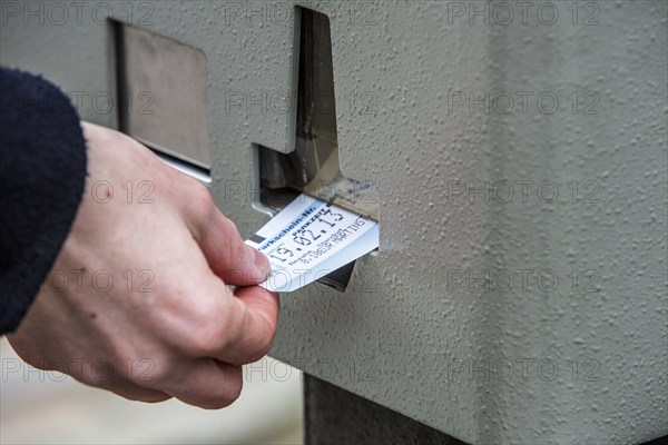 Woman purchasing a parking ticket from a parking ticket vending machine