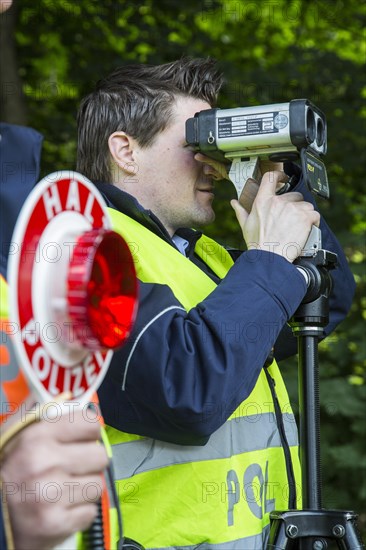 Police during speed monitoring with a laser gun or hand-held laser meter