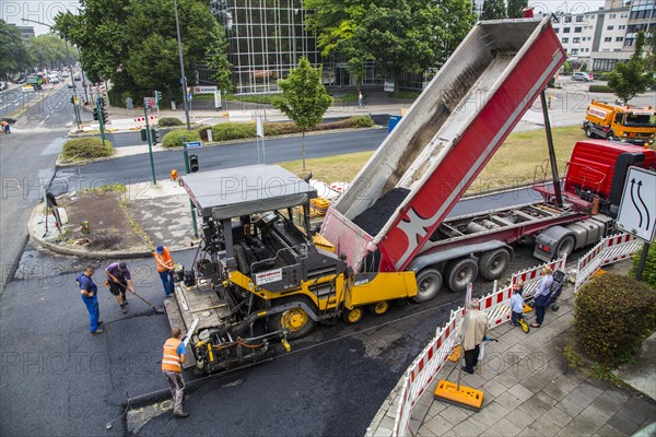 Asphalt spreader during asphalt work on a large urban road construction site