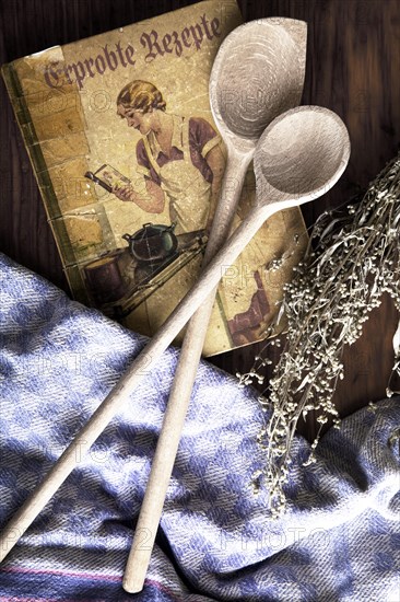 Old cookbook with wooden spoons