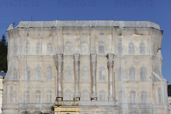 Facade of a historic building shrouded with tarpaulins during renovation